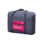 Navy folding travel bag with pink label panel and zipper closure, top handles