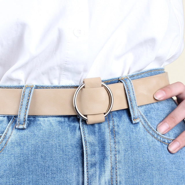 Beige wide PU leather belt with round needleless buckle on blue jeans