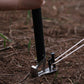Black tent stake mallet in use with claw head and stake puller on ground