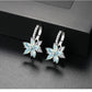 Light blue flower-shaped cubic zirconia stud earrings with silver-tone prong settings