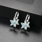 Light blue flower-shaped cubic zirconia stud earrings with silver-tone prong backs
