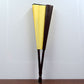 Folded blank silk fan in yellow cloth with dark brown back panels and dark wooden handle.