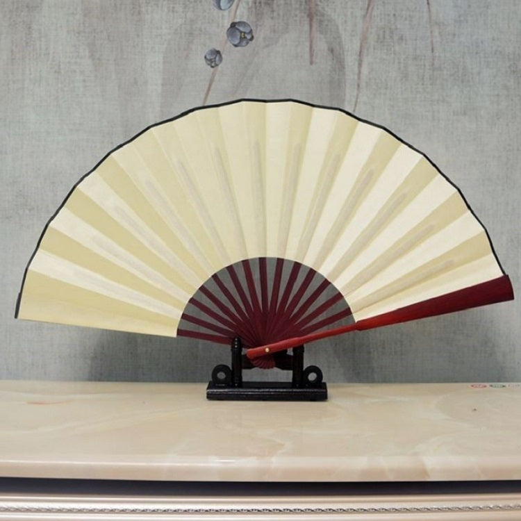 Beige-yellow blank silk folding fan with dark red inner circle and outer border on a stand.