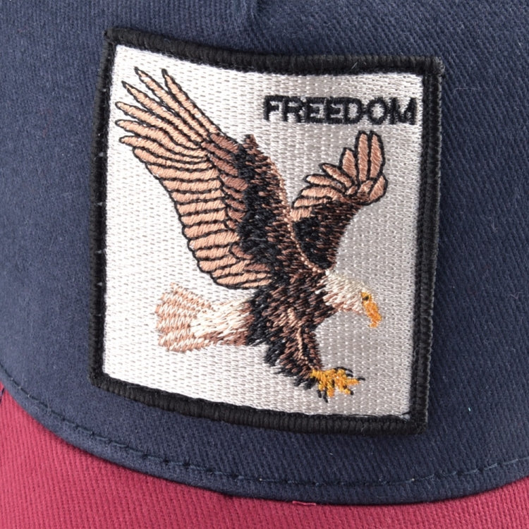Close-up of embroidered bird patch on navy baseball cap with “FREEDOM” text.