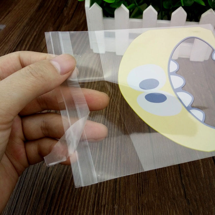 Clear OPP cookie gift bag with printed monster-face graphic, held in hand