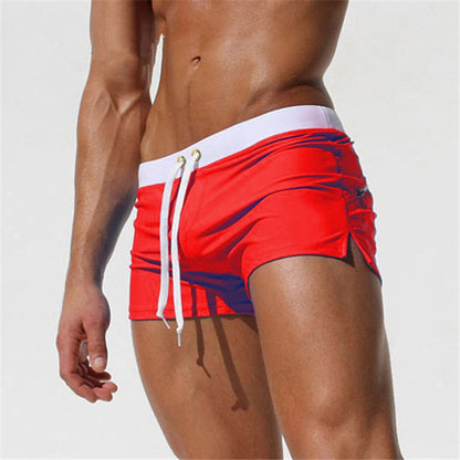 Men's red swim shorts with white drawstring and side pockets, elastic waist
