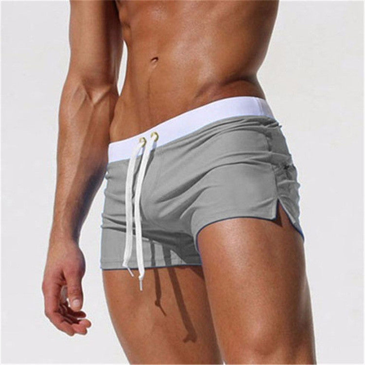 Gray men's swim shorts with white waistband trim and white drawstring, side view