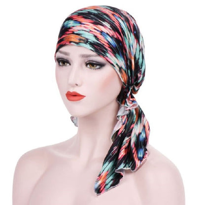 Stretch printed turban hat with long drape tail, black base with teal and coral stripes