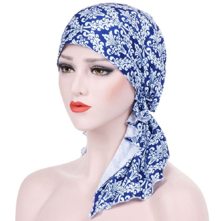 Stretch printed turban hat with long side tail, blue and white ornamental print