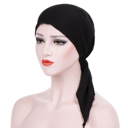 Black curved wrap cap turban hat with long side tie tail, face-framing design