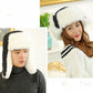 Black winter ushanka hat with white faux fur lining and triangular front logo badge