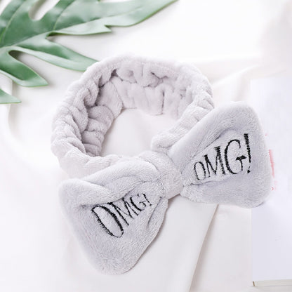 Gray plush fleece bow headband with embroidered “OMG!” letters