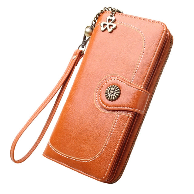 Long orange leather phone wallet with wrist strap and zipper, front snap pocket detail