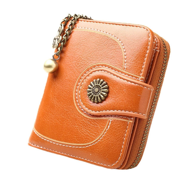 Long peach-orange leather phone wallet with chain handle and zipper, front snap pocket detail