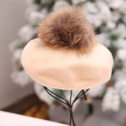 Beige plush beanie with large brown faux-fur pom-pom on top