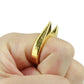 Gold-tone finger defense ring worn on a hand with sharp raised spikes