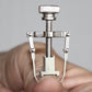 Silver toe nail care clip tool with knurled knob and U-shaped prongs
