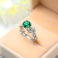 Silver-tone ring with green oval crystal and vine leaf prong setting