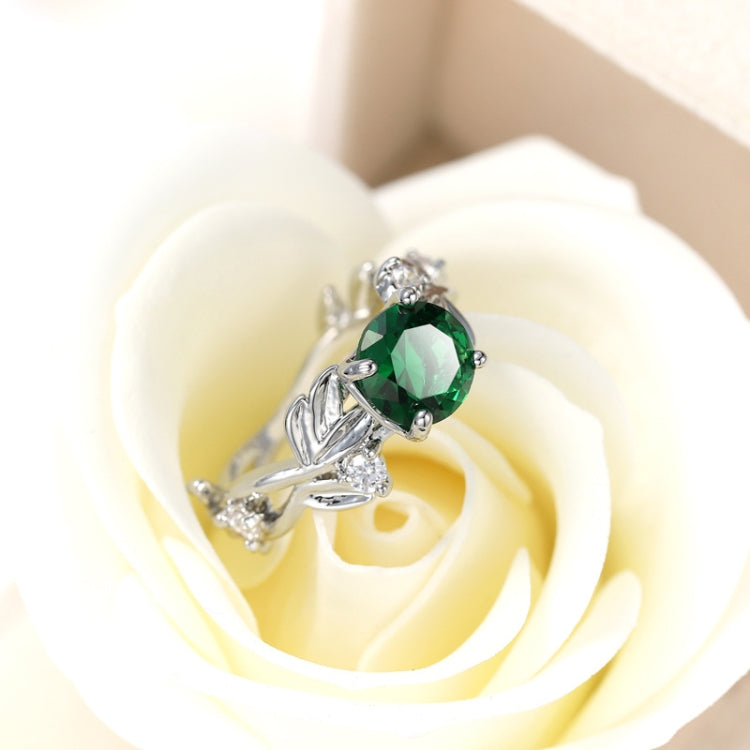 Silver-tone ring with green oval crystal centerpiece in flowerlike vine design