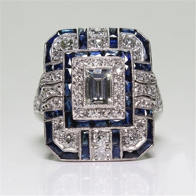 Square-cut crystal halo engagement ring with dark blue accents, silver-tone setting