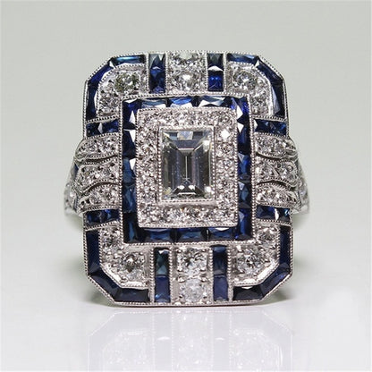 Square-cut crystal halo engagement ring with dark blue accents, silver-tone setting