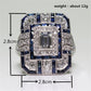 Square crystal engagement ring with rectangular center stone and blue accent gems, framed