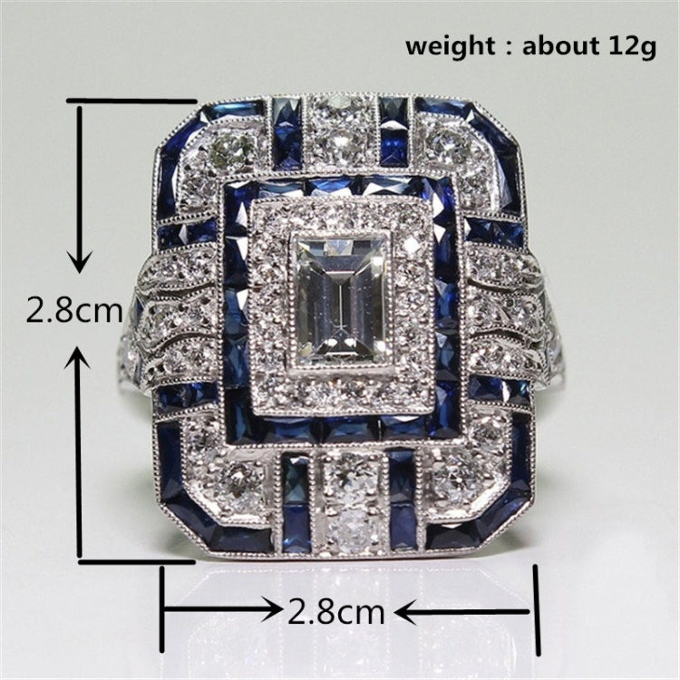 Square crystal engagement ring with rectangular center stone and blue accent gems, framed