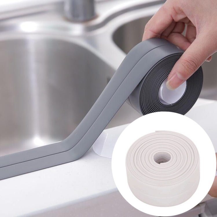 Grey waterproof adhesive sealing tape, hand applying along sink edge and corner