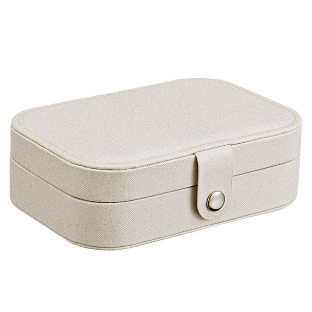 Portable jewelry storage box in light beige with hinged lid and clasp front.