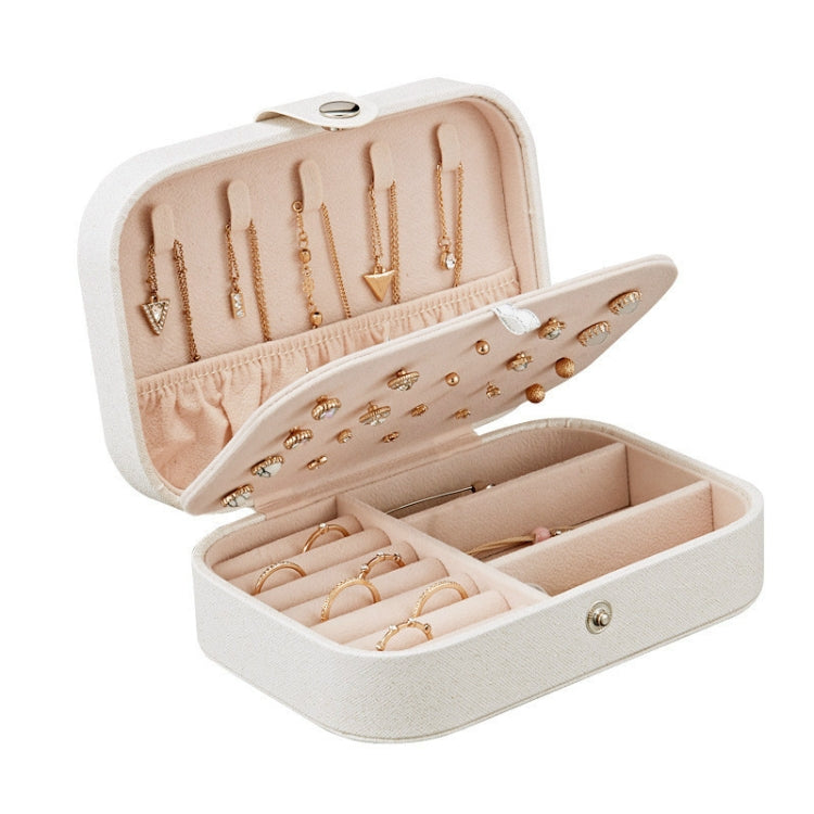 Open blush pink jewelry box with ring slots, earring plate, and inner compartments.