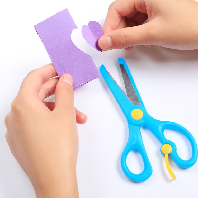 Blue safety scissors with yellow pivot, held with hands for crafting paper