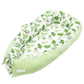 Baby nest bed with green leaf print inner and light green base, with side bow ties