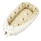 Baby nest bed with star print inner and white chevron outer, beige base and light ties