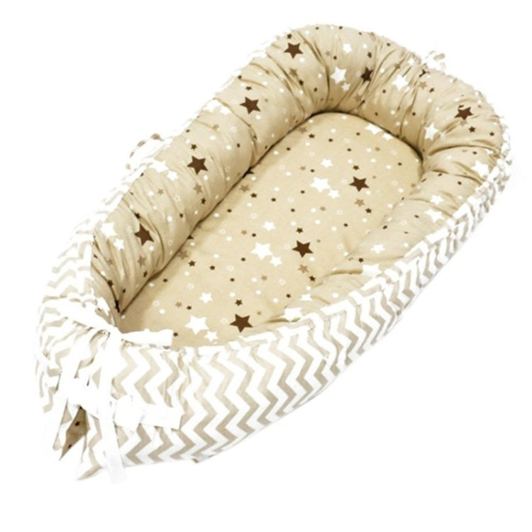 Baby nest bed with star print inner and white chevron outer, beige base and light ties