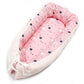 Baby nest bed with star print inner and white chevron outer, pink base with ruffled edges