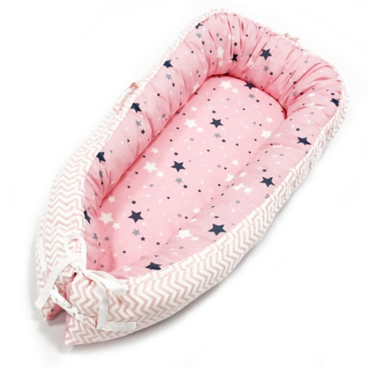 Baby nest bed with star print inner and white chevron outer, pink base with ruffled edges