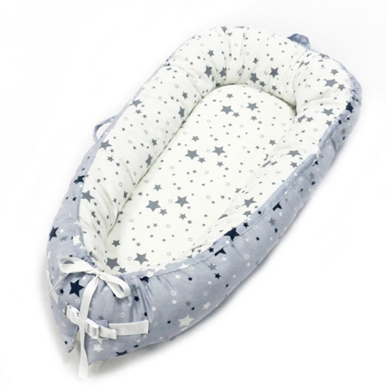 Baby nest bed with star print inner and blue chevron outer, light gray base and bow ties