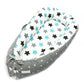 Baby nest bed with multicolor star print inner and gray chevron outer, white and teal accents