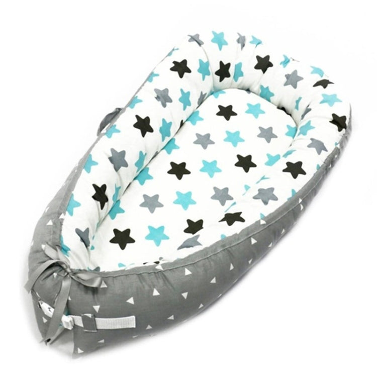 Baby nest bed with multicolor star print inner and gray chevron outer, white and teal accents