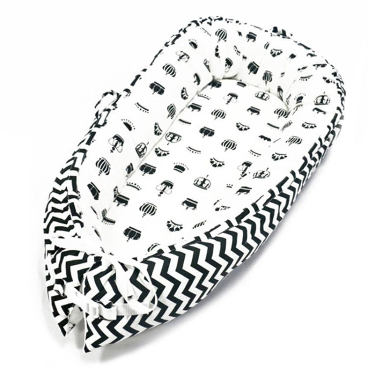Baby nest bed with vehicle print inner and black chevron outer, white base with dark accents
