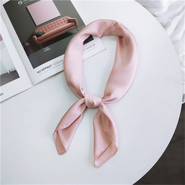 Light pink square satin scarf tied as a neck scarf with long bow