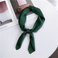 Dark green square satin scarf tied as a neck scarf with long bow ends