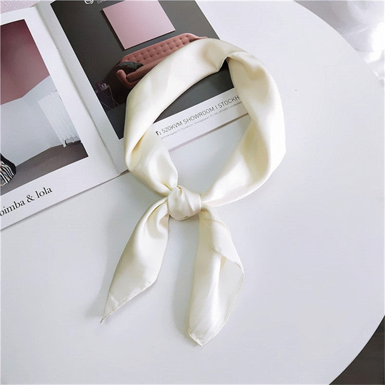 Cream square satin scarf tied as a neck scarf with long bow ends