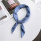 Light blue square satin scarf tied as a neck scarf with bow and tails
