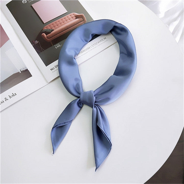 Light blue square satin scarf tied as a neck scarf with bow and tails