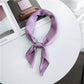 Purple square satin scarf tied as a neck scarf with long bow tails