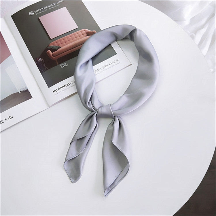 Silver gray square satin scarf tied as a neck scarf with long bow tails