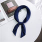 Navy blue square satin scarf tied as a neck scarf with long bow tails
