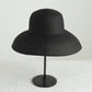 Black woven straw hat mannequin display, wide flared brim and rounded crown