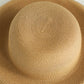 Close-up of beige woven straw hat crown with spiral stitch texture